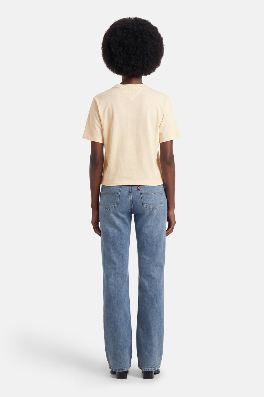 Gele T-shirt met korte mouwen van TOMMY JEANS, gedragen met een blauwe jeans.