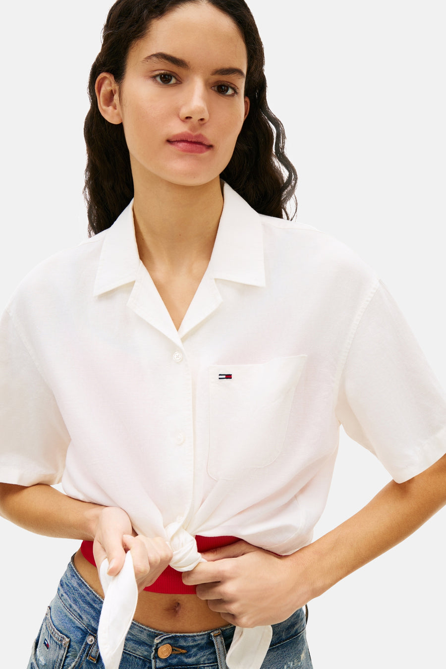 Chemise blanche à manches courtes de Tommy Jeans, nouée sur le devant et dotée d'une poche poitrine.