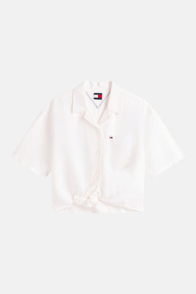 Chemisier blanc à manches courtes de TOMMY JEANS, noué sur le devant, avec poche poitrine et badge drapeau.