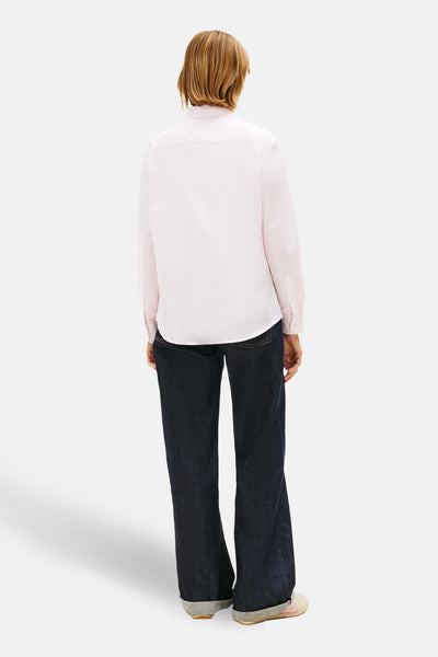 Chemise à manches longues rose de TOMMY JEANS, rayures verticales fines, portée avec un jean foncé.
