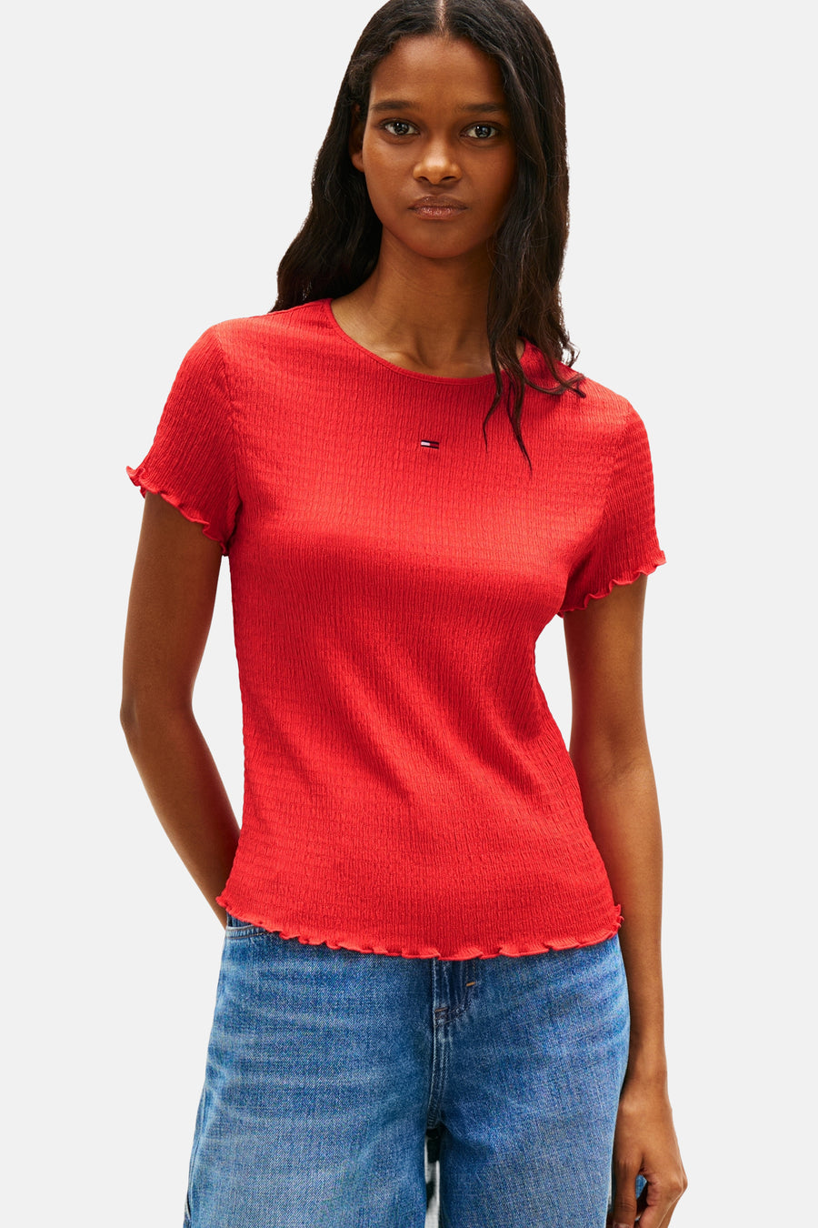 Rood T-shirt met korte mouwen van Tommy Jeans, met een golvende zoom, gedragen met een wijde spijkerbroek.