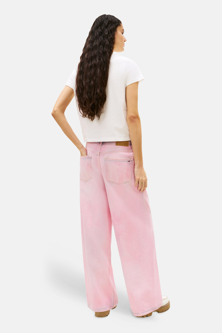Witte T-shirt met korte mouwen van TOMMY JEANS, gedragen met een wijde roze broek.