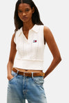 Débardeur tricoté blanc par TOMMY JEANS, avec motif torsadé et porté avec un jean taille basse et une ceinture marron.
