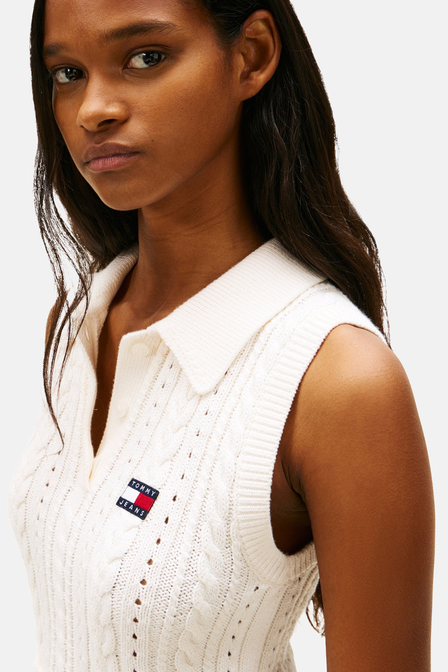Débardeur blanc en maille torsadée de Tommy Jeans, avec col polo et logo drapeau sur la poitrine.
