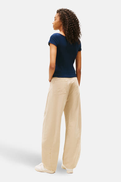 Blauw T-shirt met korte mouwen van TOMMY JEANS, gedragen met een beige wijde broek en sportschoenen.