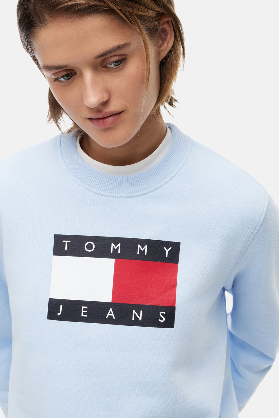 Sweatshirt bleu à col rond de TOMMY JEANS avec le logo rectangulaire emblématique sur la poitrine.