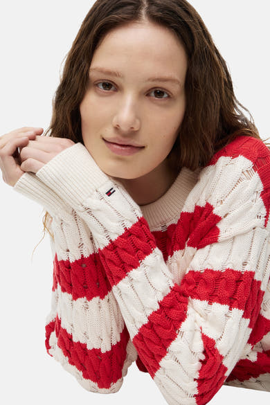 Pull col O rayé rouge et blanc de TOMMY JEANS en maille torsadée déstructurée, avec petit logo drapeau sur le poignet.