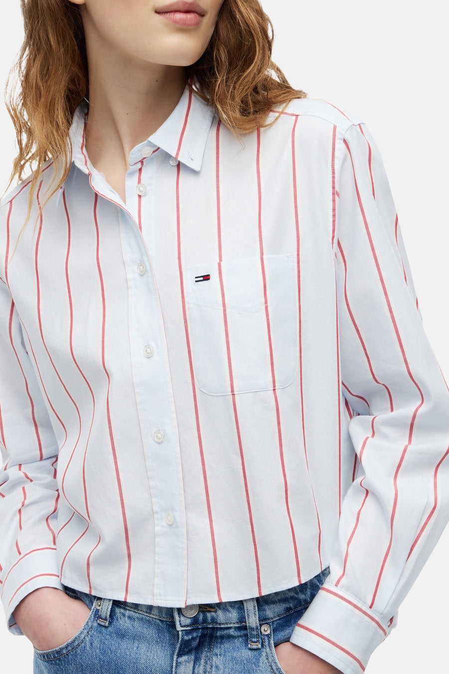 Chemise à rayures rouges et bleu clair de TOMMY JEANS avec poche poitrine et petit logo drapeau.