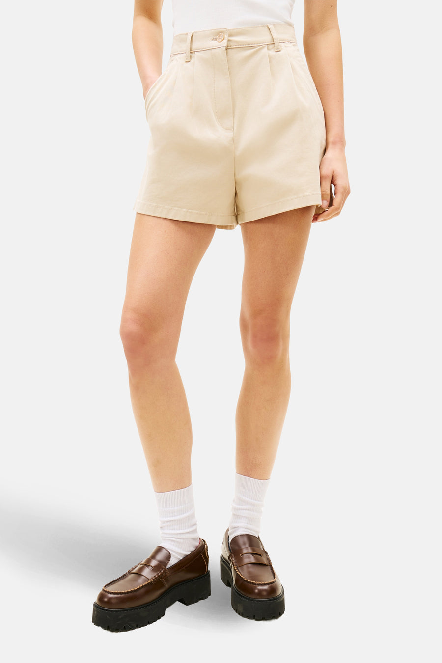 Short beige de TOMMY JEANS, porté avec un haut blanc, des chaussettes et des mocassins.