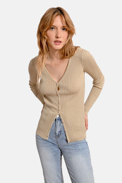Gouden ribgebreid vest van Molly Bracken, gedragen met een spijkerbroek, van achteren gezien.