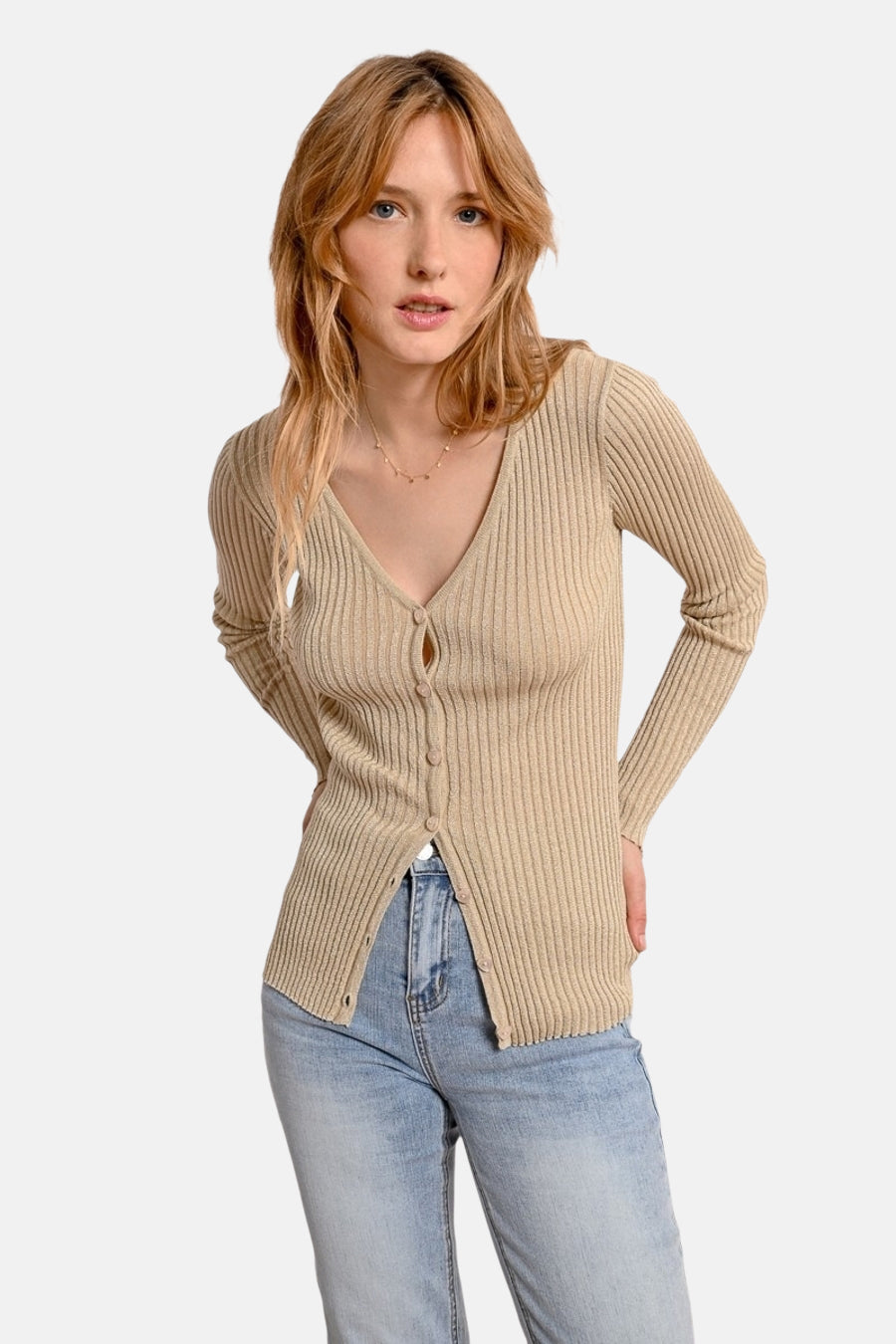 Gouden ribgebreid vest van Molly Bracken, gedragen met een spijkerbroek, van achteren gezien.