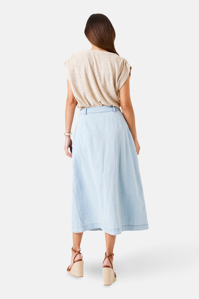 T-shirt beige à manches courtes GARCIA, porté avec une jupe longue en jean bleu clair et des compensées.
