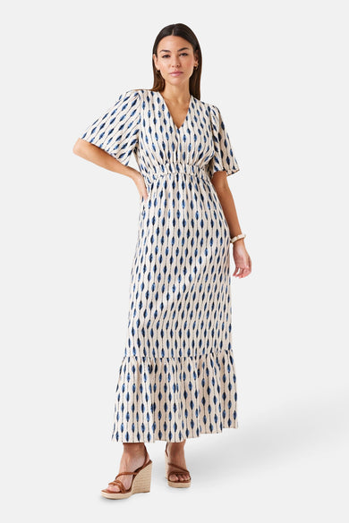 Robe longue multicolore par GARCIA, imprimé losanges bleus et blancs, avec volants et sandales compensées.
