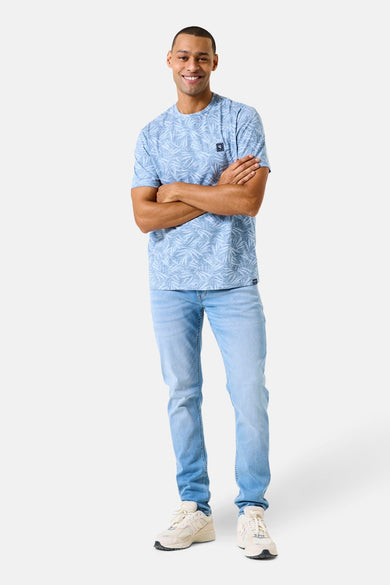 T-shirt à manches courtes bleu clair de GARCIA, à motifs végétaux, porté avec un jean clair et des baskets.