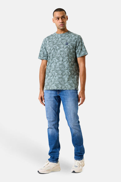 Kaki T-shirt met korte mouwen van GARCIA, met bladmotief over het gehele shirt, gedragen met een blauwe jeans en sneakers.