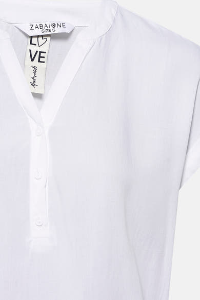 Blouse blanche à manches courtes de Zabaione avec patte de boutonnage et étiquette «live yourself».