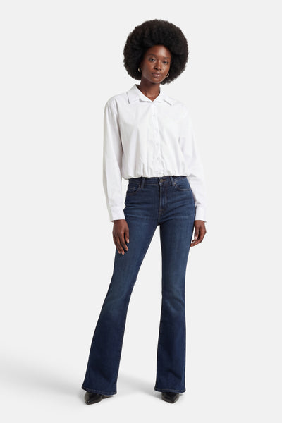 Wit overhemd met lange mouwen van AMELIE ET AMELIE, gedragen met een donkerblauwe jeans en zwarte schoenen.