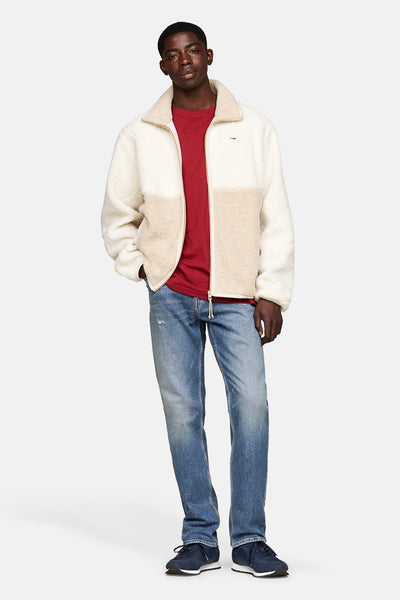 Baskets bleues de TOMMY JEANS, portées avec un jean délavé et un t-shirt rouge.