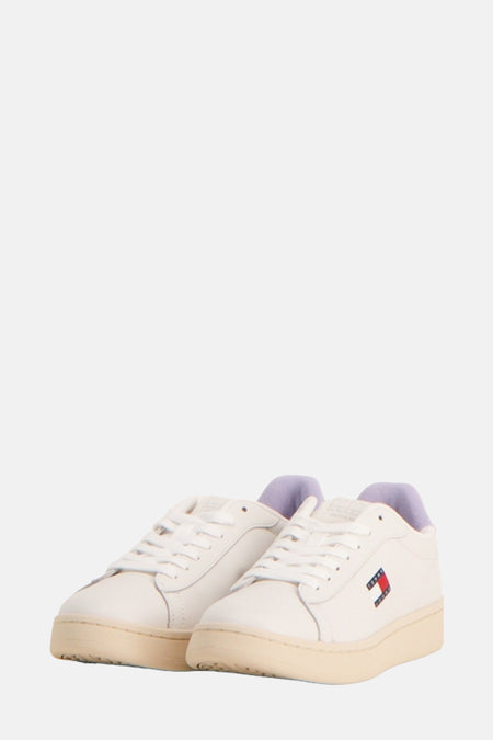 Ecru sneakers van Tommy Jeans met lila inzetstuk op de hiel en gegraveerd logo op de zool.
