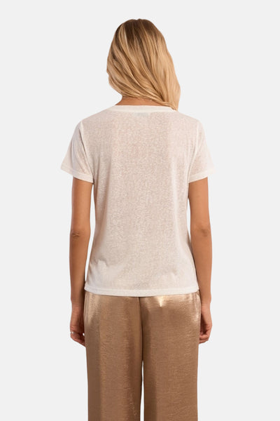 Top uni manches courtes blanc de Molly Bracken, porté avec un pantalon doré brillant, vue de dos.