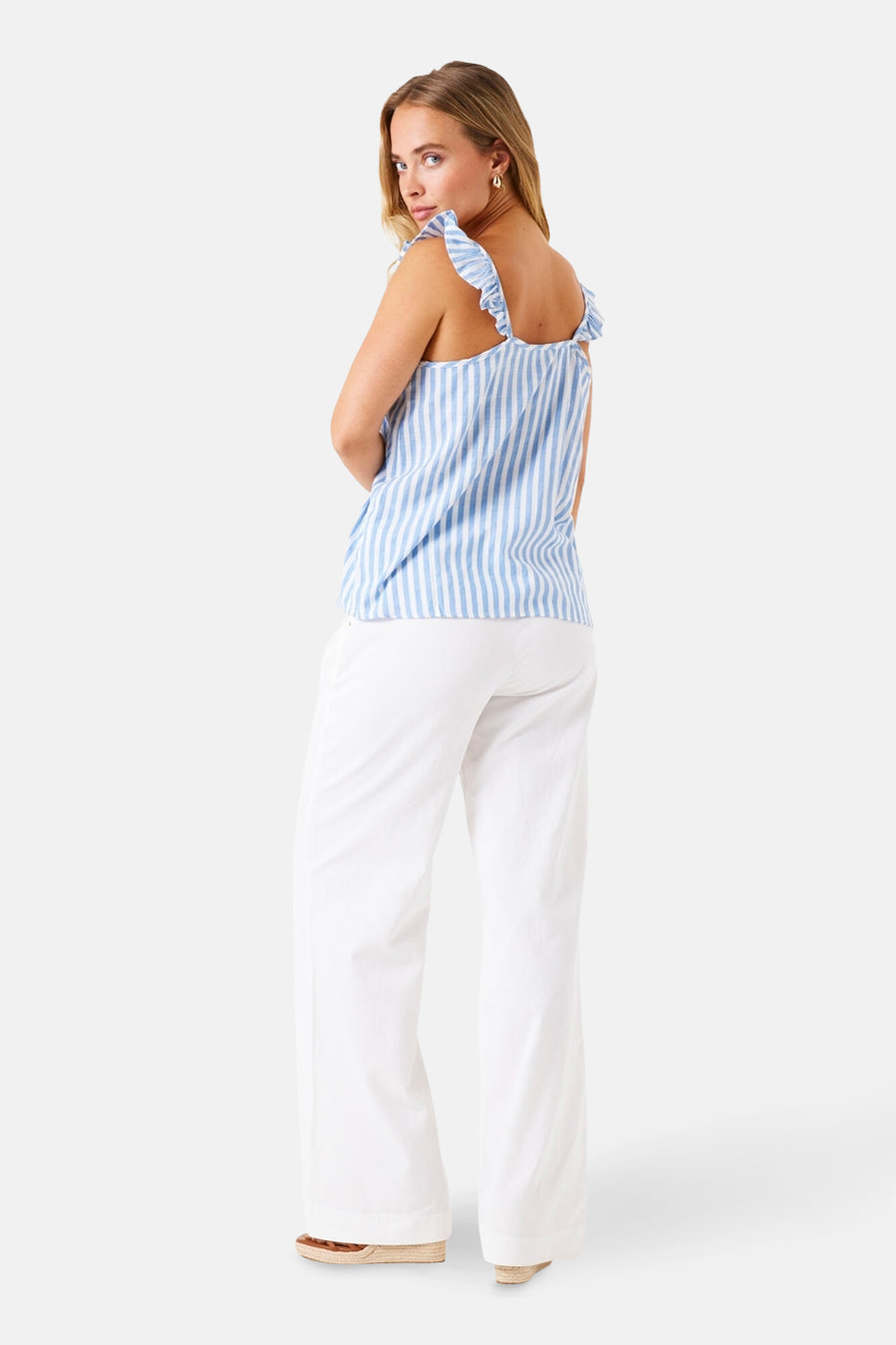 T-shirt à manches courtes bleu rayé de GARCIA, avec bretelles à volants et porté avec un pantalon blanc.
