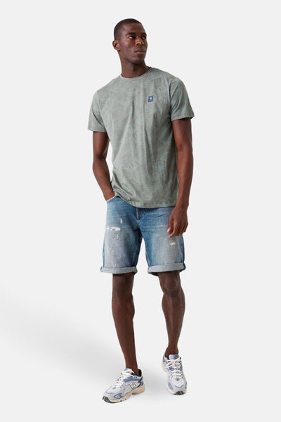 T-shirt kaki à manches courtes de GARCIA, avec motif discret, porté avec un short en jean et des baskets.
