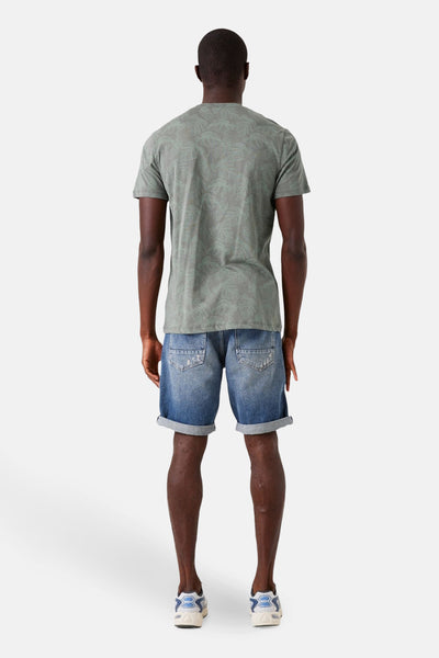 T-shirt kaki à manches courtes de GARCIA, avec motif imprimé feuilles sur l'ensemble, porté avec un short en jean bleu.