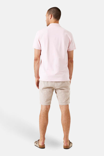 Polo rose à manches courtes de GARCIA, porté avec un short rayé et des sandales, vue de dos.
