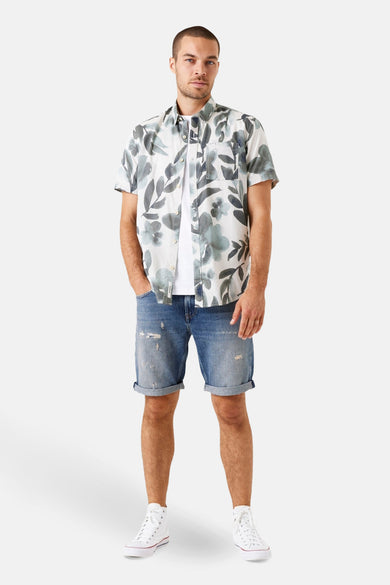 Chemise à manches courtes grise à motifs floraux de GARCIA, portée sur un t-shirt blanc et un short en jean bleu.