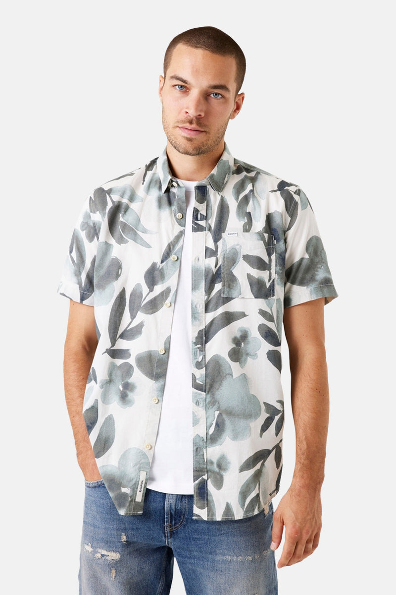 Chemise à manches courtes grise de GARCIA, avec imprimé floral et portée avec un t-shirt blanc et un jean bleu.