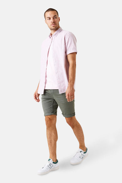 Chemise à manches courtes rose par GARCIA, portée ouverte sur un t-shirt clair et un short vert olive.