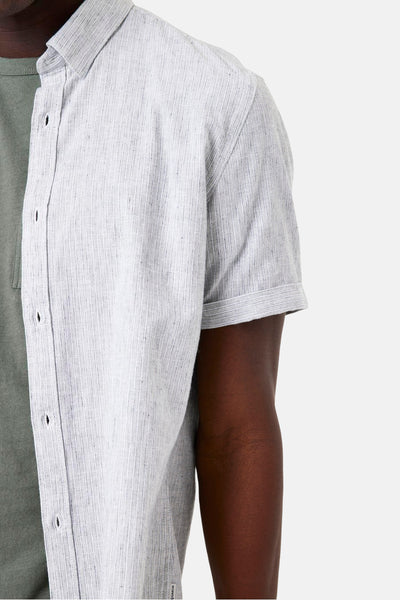 Chemise à manches courtes verte de GARCIA, rayures verticales grises et blanches, portée sur un t-shirt vert.