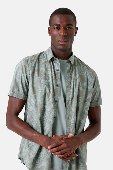 Chemise à manches courtes kaki de GARCIA, imprimé de feuilles bleues stylisées, portée ouverte sur un t-shirt uni.