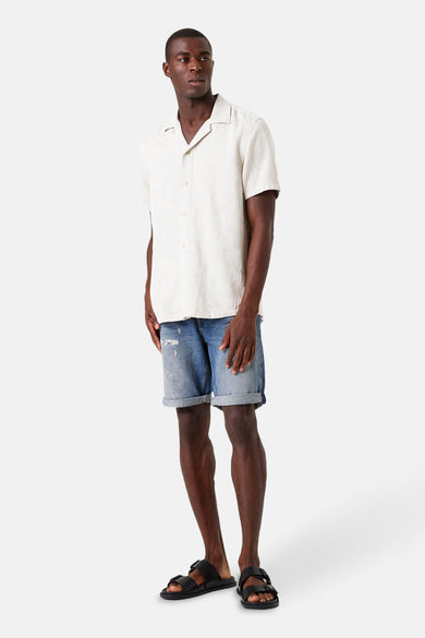 Beige overhemd met korte mouwen van GARCIA, gedragen met een spijkerbroekshort en sandalen met bandjes.