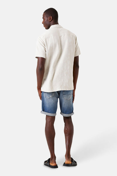 Beige korte mouwen overhemd van GARCIA, van achteren gezien, gedragen met een spijkerbroek korte broek en zwarte sandalen.