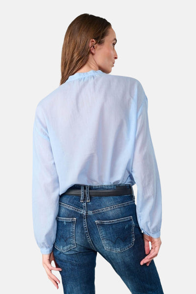 Chemisier bleu à manches longues de Le Temps des Cerises, porté avec un jean bleu et une ceinture noire, vue de dos.
