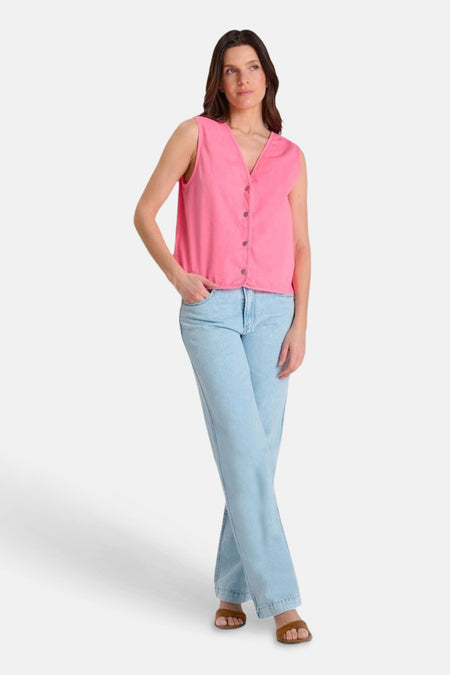 Gilet rose de Le Temps des Cerises, sans manches à col en V, porté avec un jean et des sandales.