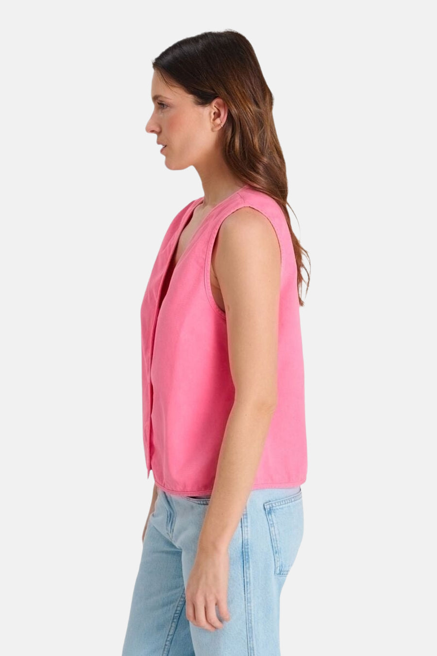 Gilet rose de Le Temps des Cerises, sans manches, boutonné, avec un col en V, vu de profil, porté avec un jean clair.
