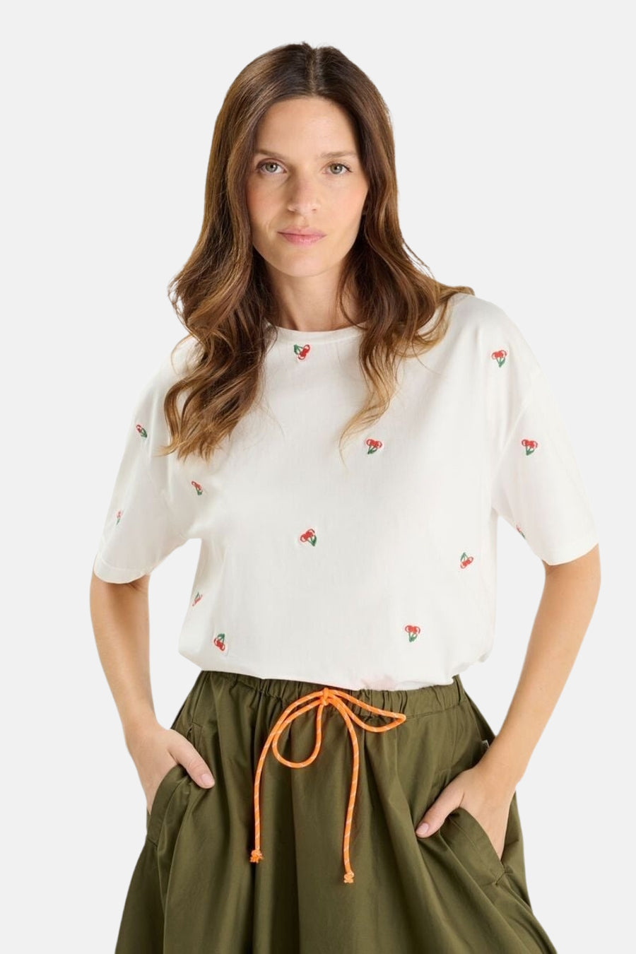T-shirt blanc à manches courtes de Le Temps des Cerises, motif brodé cerises, porté avec un pantalon kaki.
