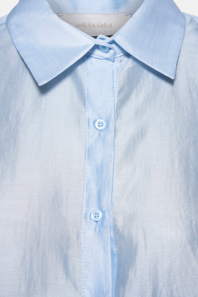 Chemise bleu clair à manches longues par AMELIE ET AMELIE, avec col et boutons sur le devant.