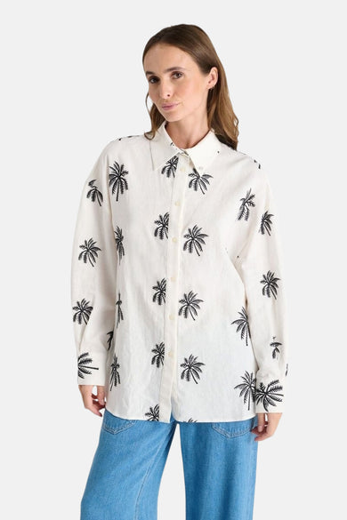 Wit overhemd met lange mouwen van Le Temps des Cerises, met zwart palmboomprintpatroon, gedragen met een spijkerbroek.