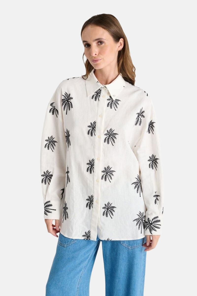 Wit overhemd met lange mouwen van Le Temps des Cerises, met zwart palmboomprintpatroon, gedragen met een spijkerbroek.