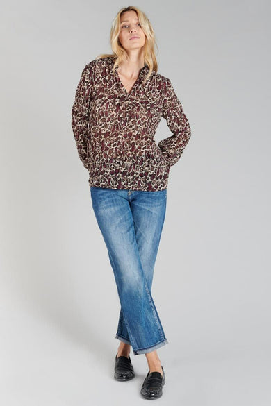 Chemisier bordeaux à manches longues de Le Temps des Cerises, avec motif imprimé, porté avec un jean bleu et des mocassins noirs.