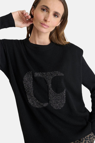 Débardeur gris moyen en denim par Le Temps des Cerises, porté sur un pull noir uni avec un motif décoratif.
