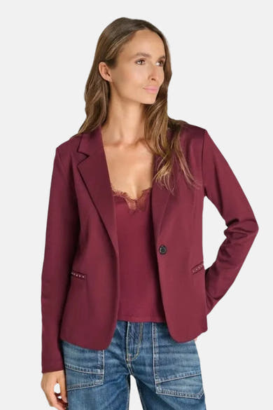 Blazer bordeaux de Le Temps des Cerises, coupe ajustée avec poches ornées de clous, porté sur un haut dentelle et jeans, vue de face.