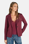 Blazer bordeaux de Le Temps des Cerises, coupe ajustée avec poches ornées de clous, porté sur un haut dentelle et jeans, vue de face.