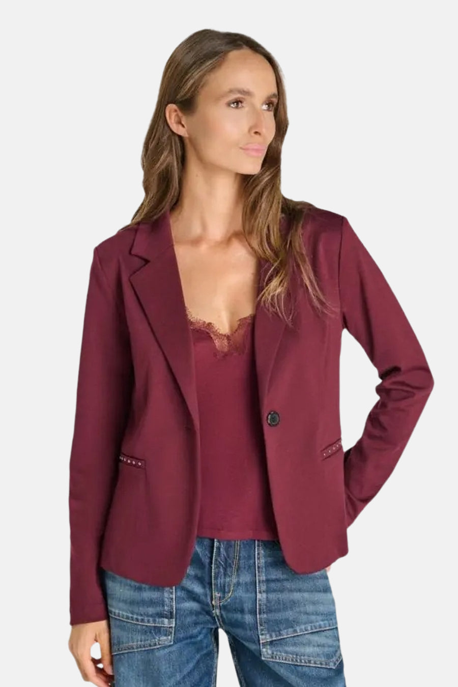 Blazer bordeaux de Le Temps des Cerises, coupe ajustée avec poches ornées de clous, porté sur un haut dentelle et jeans, vue de face.