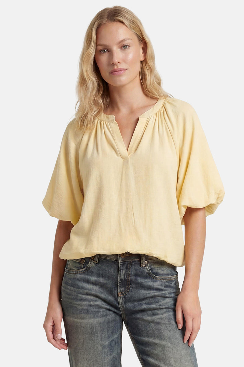 Yellow 3/4 sleeve blouse with gathered neckline and flowy sleeves, worn with dark jeans, front view