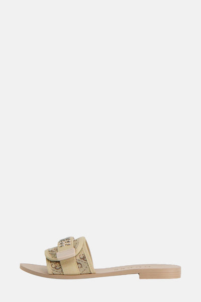 Beige sandaal met logoprint van Guess, met gespdetail en platte zool.