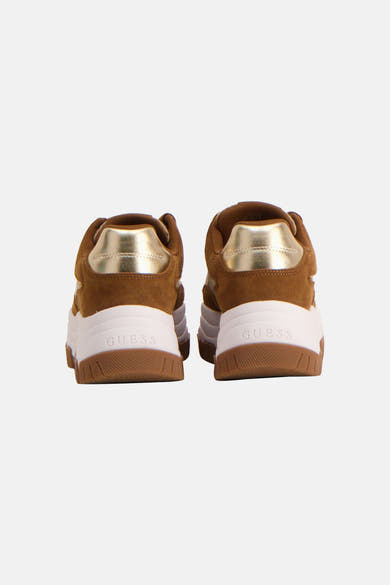 Bruine Guess-sneakers met gouden bies op de hiel en dikke witte zool.